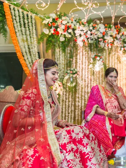 A candid moment of a bride sharing a laugh with her mother during a ceremony. This image beautifully captures the precious family connections on a wedding day.