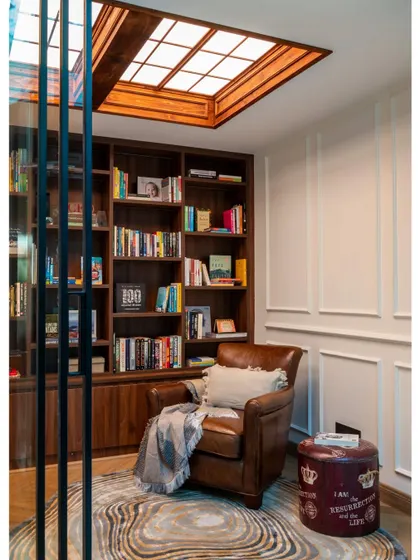 A vertical shot of the library, emphasizing the height of the bookshelves and the beautiful wooden frame of the skylight. This detail shot is from a feature on our "Villa Tranquility" project.