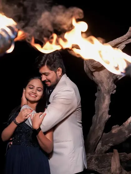 An intimate embrace, framed by flaming torches. The warm light of the fire creates a romantic and intense atmosphere.