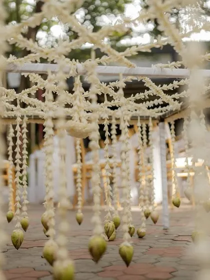 A close-up view from under a floral chadar, showing the intricate jasmine weave.