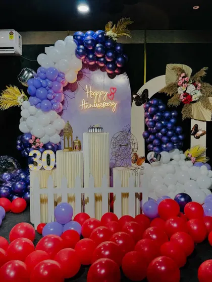 This wide shot shows the full 30th anniversary decoration, with red balloons scattered on the floor to add a pop of color and fill the space. We can customize the color scheme to match your preference.