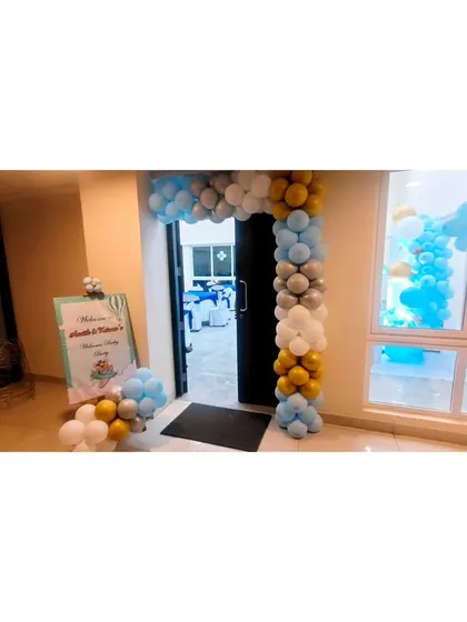 The entrance to a welcome baby party with a balloon arch.