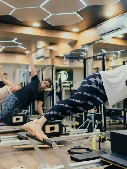 The side plank is a powerful move for targeting the obliques and improving lateral stability. Here, a group class works in unison, showcasing the strength and focus that Pilates cultivates.