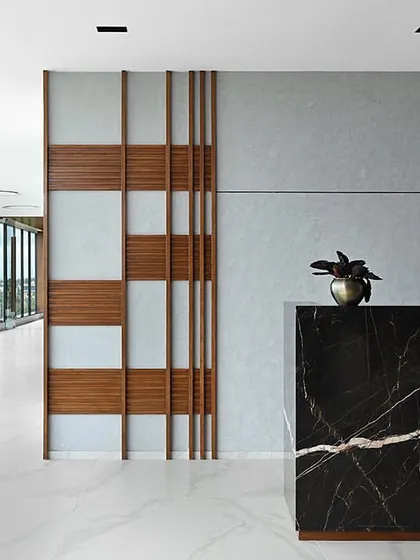 The reception area showcases a bold black marble desk and a decorative wood-paneled screen, setting a modern and luxurious tone for the entire office.