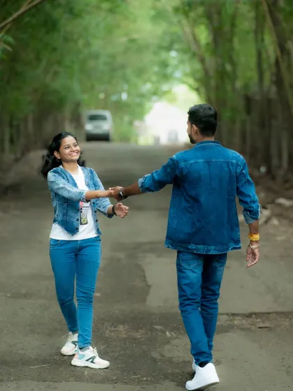 A candid "follow me" style pre-wedding shot, with the couple walking down a tree-lined country road, capturing a sense of journey and togetherness.