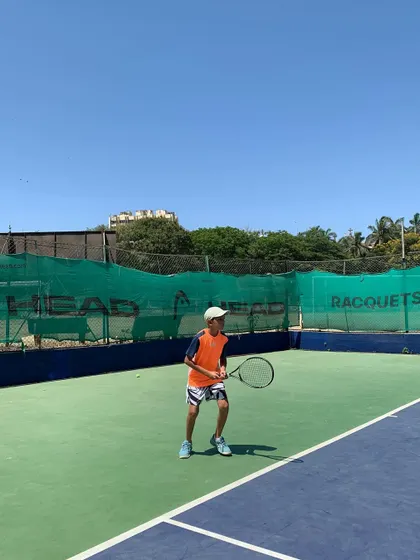 A junior player prepares to receive a serve during a sunny match day at our Season 12 tournament.