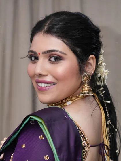 A bright smile completes this function-ready look. The makeup is flawless and radiant, ensuring she looks her best for the celebration.