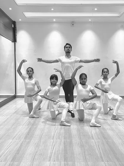 A group of young ballerinas in a synchronized pose with me during a class. These photos show the discipline and coordination we build in our ballet program.