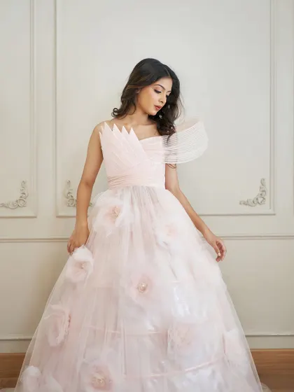 A detailed shot of the 'Carol' gown's bodice, highlighting the intricate wired draping and the soft texture of the 3D flowers on the skirt.