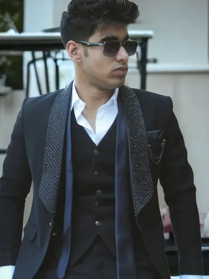 Another shot of the black suit with a textured lapel, showing a confident and stylish pose.