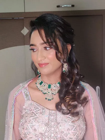 The side-swept bangs and loose curls add a touch of romance to the look.
