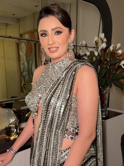 Drenched in shimmers, this look is all about angelic glam. The makeup is soft and luminous, with a focus on bright, open eyes and glowing skin that perfectly complements the sparkling silver saree.