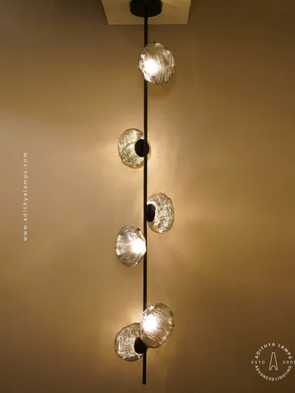 This vertical fixture features textured, moon-like chrome orbs attached to a central black rod. It's a striking, artistic piece that works well in corners or narrow spaces, adding a touch of celestial-inspired modernism.