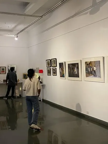A visitor looking at the framed artworks in 'Southern Stars'.