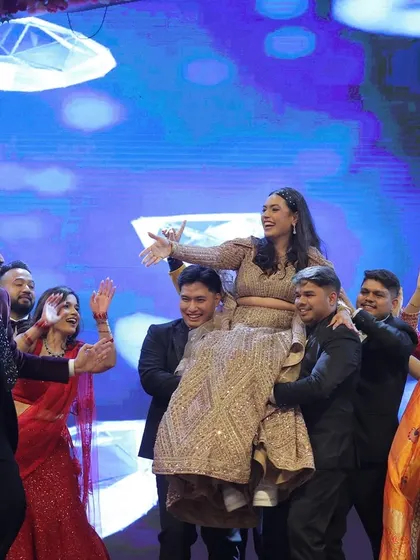 The grand finale of a couple's performance, with friends lifting the bride up in celebration. These high-energy moments are what make a sangeet unforgettable.
