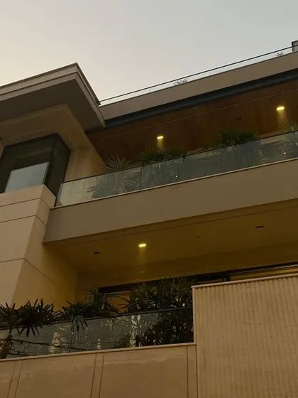 As evening approaches, integrated lighting on the balcony ceilings casts a warm glow, highlighting the wooden ceiling panels and creating an inviting ambiance.
