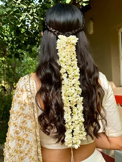 Who says a gajra can only be worn in a bun? For this mehendi, we created a beautiful gajra half-updo to go with her traditional white and gold lehenga.