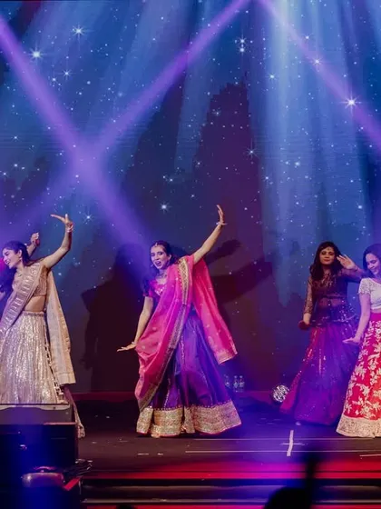 A large group of family and friends performing on a grand stage. The purple and blue lighting created a magical, starry-night effect.