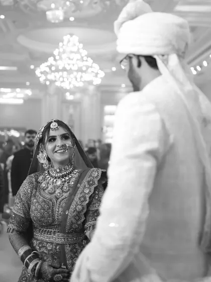 A candid black and white photo of the bride's joyful expression as she sees her groom at the start of the ceremony.
