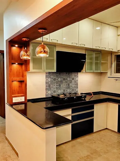 This kitchen features a peninsula with a black granite top that serves as a breakfast counter. The design cleverly separates the kitchen from the rest of the home while keeping it open.