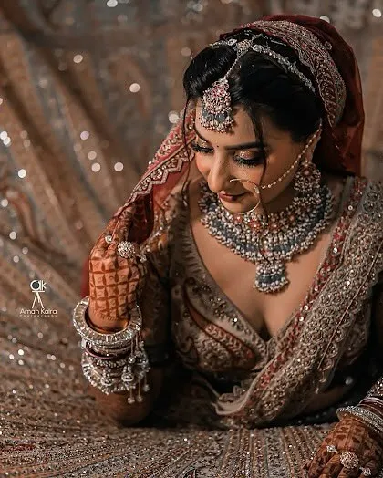 A breathtaking shot of a bride surrounded by her glittering lehenga, her beauty enhanced by our complete Polki and diamond-look bridal set.