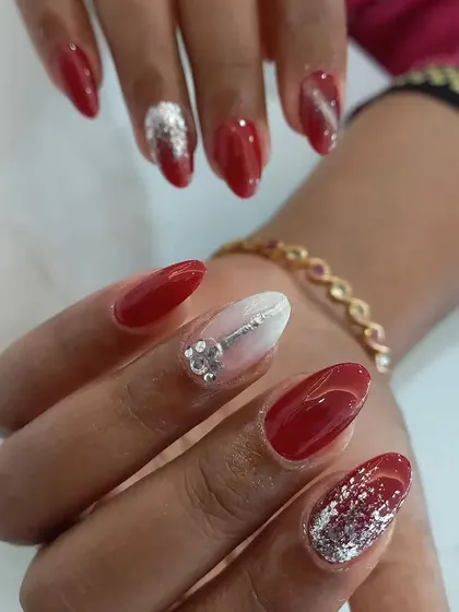 A classic red manicure gets a glamorous update with silver glitter accents and a 3D silver key charm.
