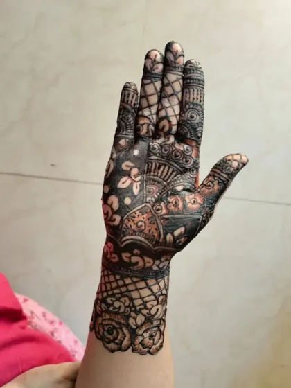A closer look at a floral-dominant bridal mehendi. This design features beautiful rose patterns on the wrist cuff and intricate detailing across the palm and fingers.