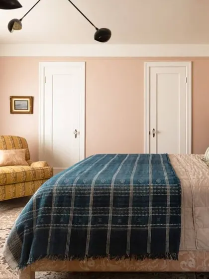 This bedroom uses a warm, dusty rose on the walls to create a cozy and inviting feel. It's a sophisticated choice that pairs well with both modern and vintage decor.
