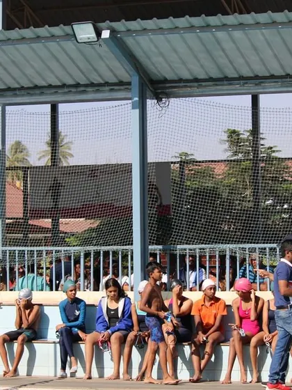 Swimmers waiting for their events by the poolside. The camaraderie and shared excitement are a huge part of our competition days and summer camps.