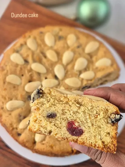 This is a slice of my Dundee Cake, a non-alcoholic Christmas option. It's a lighter fruit cake, characterized by the pattern of blanched almonds on top.
