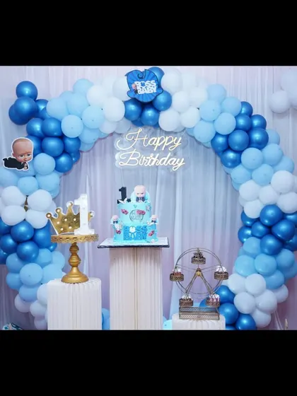 A simple Boss Baby setup with a beautiful blue and white balloon arch, perfect for cake cutting.