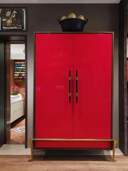 A striking red lacquered bar cabinet, designed by us, adds a bold pop of colour to the study. This piece, named the 'Raspberry Bar', is both a functional storage unit and a sculptural object that enlivens the space.
