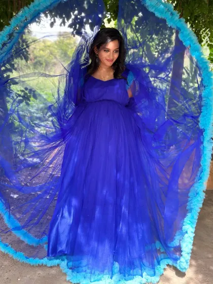 The royal blue maternity gown creates a stunning visual, making the expecting mother the center of a beautiful frame.