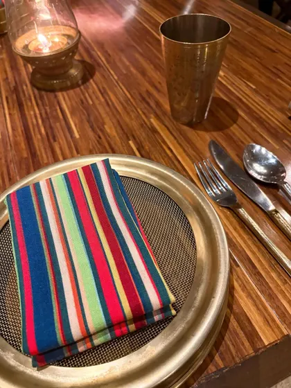 The vibrant table setting at Loya. The colorful napkin against the traditional brass thali speaks to the restaurant's blend of modern and heritage aesthetics, a detail I knew my audience would appreciate.