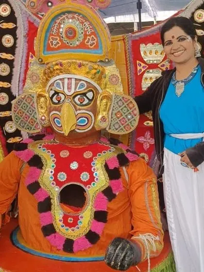 Posing with a traditional Yakshagana mask at the Karavali Utsav.