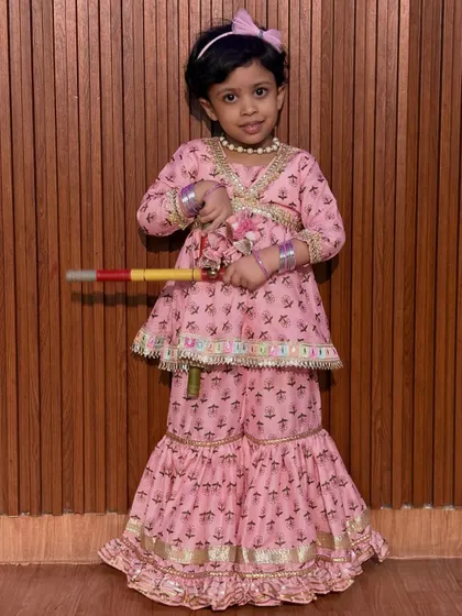 This little one is ready for Dandiya in her pretty pink sharara set. Our classes are open to kids of all ages, helping them connect with cultural traditions from a young age.