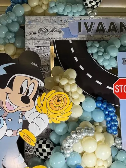 A close-up of the main backdrop, showing the Mickey Mouse character prop against the balloon-covered racetrack.