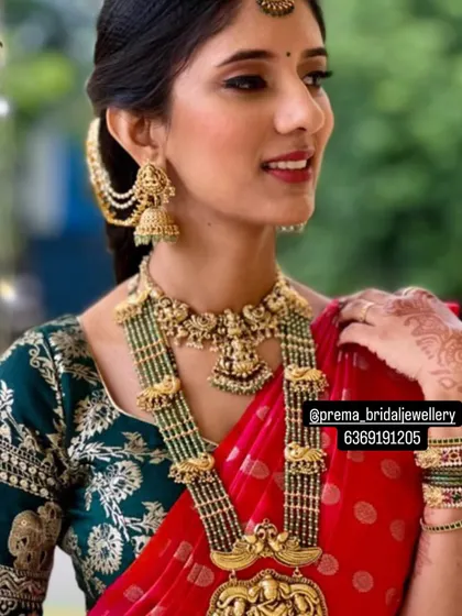 A detailed look at the bride's layered necklace set, which includes a beautiful choker with goddess motifs and a multi-strand beaded haaram.