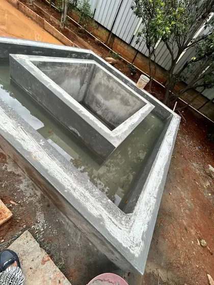 A custom-built, multi-level concrete water feature or planter during the construction phase, showing the structural work that goes into creating unique garden elements.