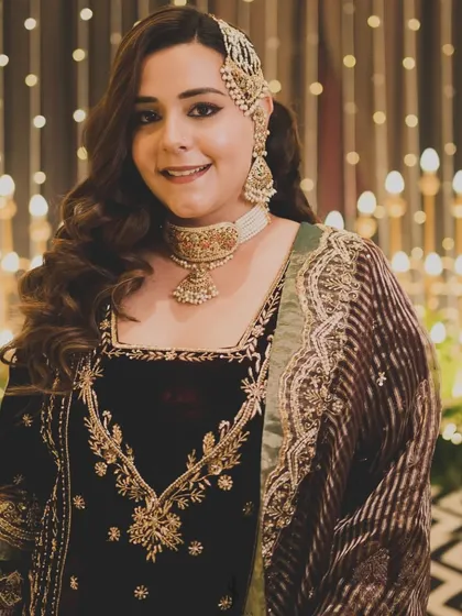 A portrait of the bride, showcasing her full reception look. The rich velvet, intricate embroidery, and elegant jewelry create a truly unforgettable style.