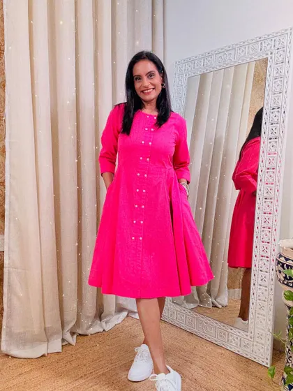 A bright pink fit-and-flare dress with button details. This is a very cute and feminine dress, perfect for a casual day out.