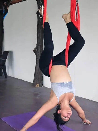 The joy of a supported inversion. Aerial yoga makes challenging poses accessible, allowing students to experience the benefits of being upside down with ease.