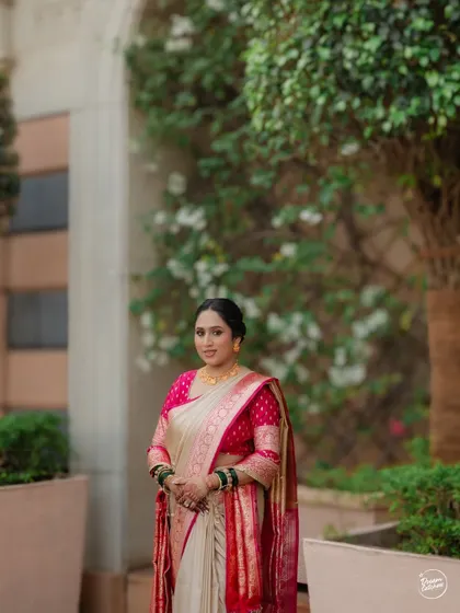A full-length portrait of the bride in her beautiful pink and cream saree, looking graceful and elegant.