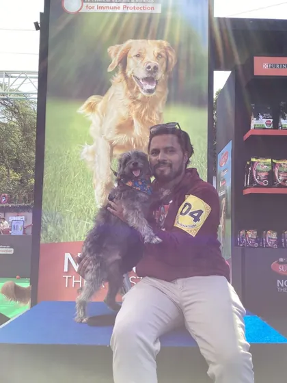 A happy pet owner and their furry companion posing at our booth at PetFed. We ensure our setups are welcoming and easy to use for all guests, human or animal, to capture the best moments.