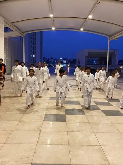 Students at the Prestige Falcon City dojo warm up with basic movements, preparing their bodies and minds for the focused training ahead.