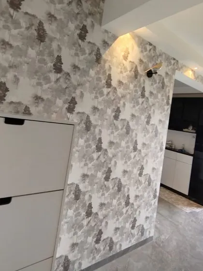 A misty forest wallpaper in monochrome tones adds depth and a calming atmosphere to this hallway, seamlessly connecting to the modern kitchen area.