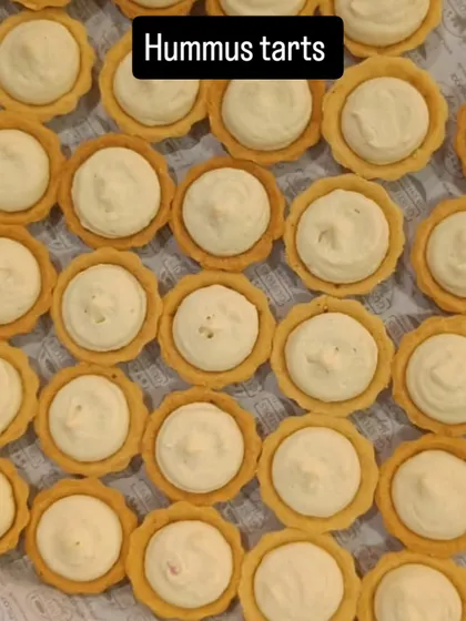 Hummus tarts fill our tray in neat rows, showing an individual savoury choice for a bakery catering menu.
