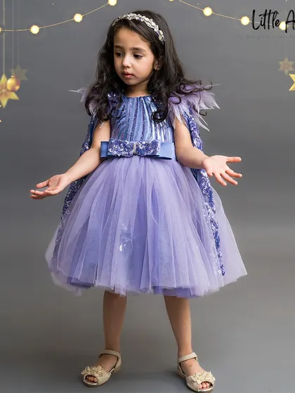 The "Betty Lilac" dress features a sequined bodice and a feathered cape for a touch of glam.