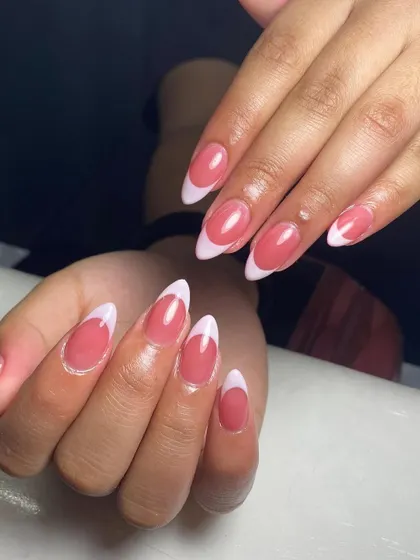 A beautiful example of a classic French manicure on almond-shaped nails, showing off the clean lines and glossy finish.