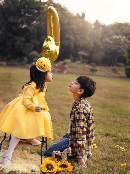 The original shot from a sunny birthday session in the park. The bright yellow outfits and sunflowers create a cheerful and vibrant theme for this sibling portrait.